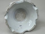 a white bowl that has a small hole in the middle of it