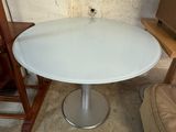 une table et une chaise blanches dans un coin d'une pièce