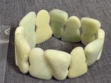 un bracelet composé de pierres vertes sur un fond gris