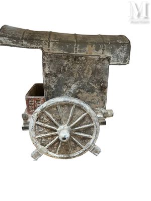 une petite charrette en bois surmontée d'un canon
