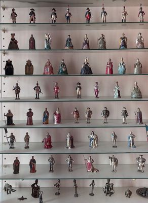 de nombreuses figurines exposées sur des étagères en verre dans une vitrine