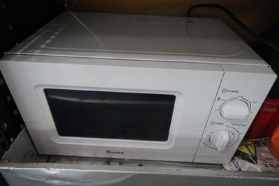 un micro-ondes posé sur une boîte