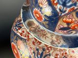 a blue and red vase with a lid on a table
