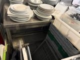 beaucoup d'assiettes et de casseroles empilées sur une étagère