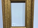 un cadre photo doré posé sur une table en bois