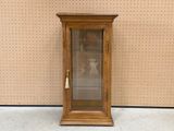 une petite armoire en bois munie d'une porte vitrée