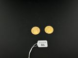 a pair of gold coins with a price tag attached to them