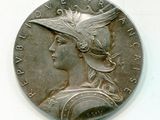 pièce d'argent représentant la tête d'une femme coiffée d'un chapeau orné de plumes