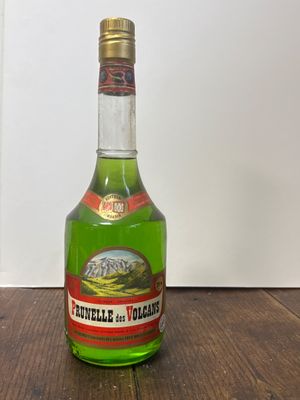 une bouteille contenant un liquide vert posée sur une table en bois