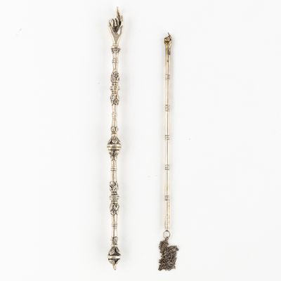 two silver spoons and a spoon with a handle on a white surface