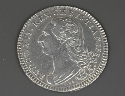 gros plan d'une pièce de monnaie sur laquelle figure un visage de femme