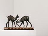 sculpture représentant deux cerfs sur un socle, dans une pièce blanche