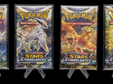 three packs of pokemon trading cards are displayed on a black background