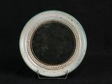 a white plate with a mirror on it on a black background