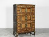 une commode ancienne avec des ferrures en laiton et des panneaux en bois