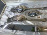four silver spoons and a knife in a box