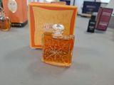 a bottle of perfume sitting on a table next to a box of perfumes