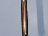 a small metal object with a wooden handle on a table