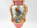 a pink vase with a painting of birds on it