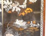 two black and gold painted panels with birds on them
