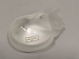 a white mouse sitting on a table next to a plastic cup