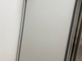 a white refrigerator in the corner of a room