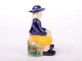 a figurine of a man sitting on a stool