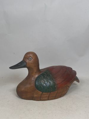 a wooden duck that is sitting on a table
