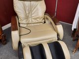 une photo d'un fauteuil de massage dans une pièce aux murs rouges