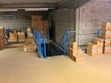 Les cartons sont empilés sur des palettes dans un grand entrepôt aux murs en béton