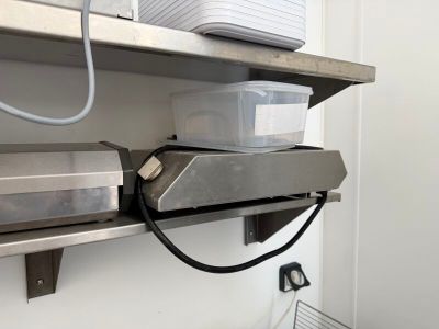 une étagère métallique sur laquelle sont posés un micro-ondes et un four à micro-ondes