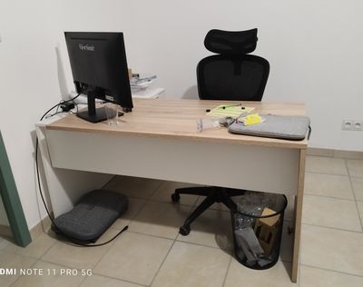 un bureau avec un ordinateur et une chaise dans un coin