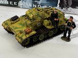 a small toy tank with two men standing next to it