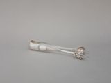 une cuillère en argent et un repose-cuillère posés sur une table