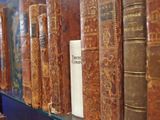 many old books on a shelf in a library