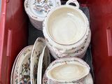 une boîte rouge contenant tout un tas d'assiettes et de bols