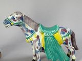 two figurines of a horse and a horse with a saddle