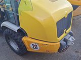 two yellow tractors parked next to each other in a parking lot
