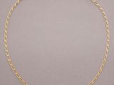 a gold chain necklace with a link on a grey background