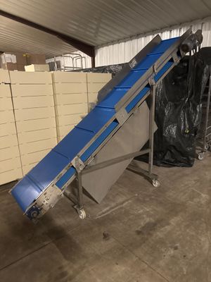 un tapis roulant sur lequel se trouve une bande bleue, dans un entrepôt