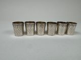 four silver cups with wavy designs on them