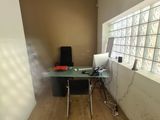 a desk with a computer on it in the corner of a room