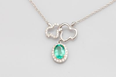 Gros plan sur un collier orné d'une pierre verte