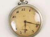 a close up of a pocket watch on a white surface