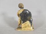 a figurine of a man sitting on a rock