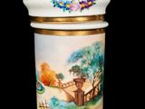 a white vase with a painting on it on a black background