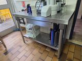 a kitchen with a stainless steel table and a microwave on it