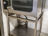 a silver microwave sitting on a stand in a kitchen