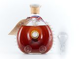 a bottle of brandy next to a glass of wine
