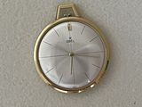 a gold wrist watch with a white face on a white surface
